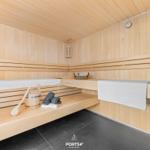 Sauna with wooden bench, towel, and water bucket