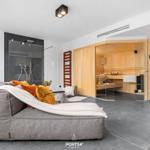 Living area with sauna and shower. Large sofa with blanket and cushions.