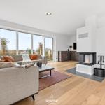 Living room with sofa, fireplace, and large windows