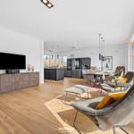 Living and dining area with modern furniture and wooden floor.