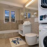 Bathroom with bathtub, toilet, and washing machine.