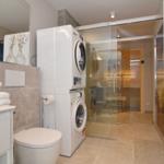 Bathroom with washing machine, dryer, and shower