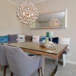 Dining room with glass top, gray chairs, and cushioned bench.