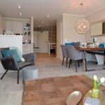 Living and dining area with modern furniture and wooden floor.