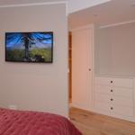 Bedroom with bed, TV, and dresser