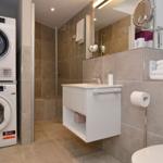 Bathroom with shower, sink, and washing machine