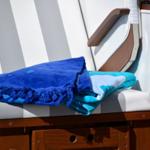 Blue and turquoise towels on striped lounge chair