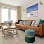 A living room with brown sofa, green cushions, and wooden table.