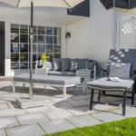 Terrace with garden furniture, parasol, and view into the house.