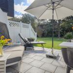 Terrace with seating, umbrella, and flower arrangements.