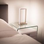 Bedroom with bed, nightstand, and modern lamp.