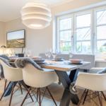 Dining room with table, chairs, and windows.