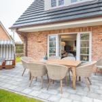 Terrace with dining table, chairs, and beach chair. View into the kitchen.
