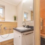Bath with bathtub, mirror, and sauna