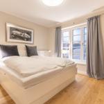 Bedroom with double bed, window and armchair.