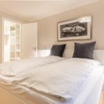 Bedroom with double bed, nightstand, and picture on the wall.