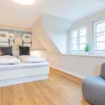 Bedroom with double bed, windows, and armchair