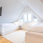 Room with two beds, window, and TV on the wall.