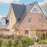 Two-story brick house with dormers and wooden garage.