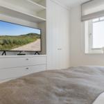 Schlafzimmer mit Bett, Fernseher und Fenster