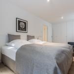 Schlafzimmer mit Doppelbett, Nachttisch und Kleiderschrank.