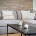 Grauer Sofa mit Kissen und Tisch mit Kerzen.