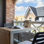 Terrace with table, chairs, and view of rooftops.
