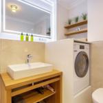 Bathroom with washing machine, sink, and mirror