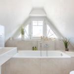 Bathroom with bathtub, sink, and skylight