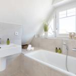 Bathroom with bathtub, sink, and window