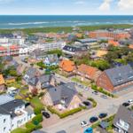 Houses and streets by the coast with a view of the sea.