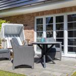 Terrasse mit Liegestuhl, Tisch und Stühlen vor Backsteinhaus