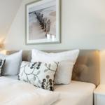 Doppelbett mit Kissen und Bild an der Wand