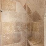 Dusche mit Steinwand und Sitzbank