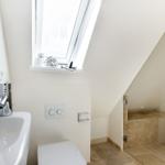 Badezimmer mit Dusche, Waschbecken und Dachfenster