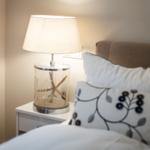 Schlafzimmer mit Nachttisch, Lampe und Kissen