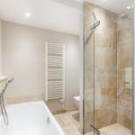 Badezimmer mit Badewanne, Dusche und Toilette.