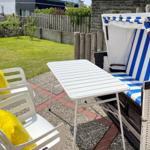 Backyard with garden, table, chairs, and beach chair.