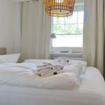 Bedroom with bed, window, and wall lamp