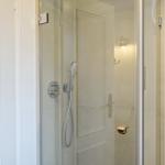 Shower cabin with glass door and handheld shower