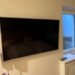 Wandmontierte TV-Anlage neben Fenster mit Aussicht