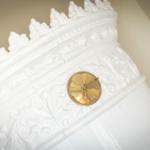 Weiße, verzierte Kaminverkleidung mit goldener Kaminuhr