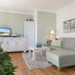 Wohnzimmer mit Sofa, Couchtisch und Fernseher.