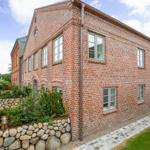 Red brick house with garden and stone wall.