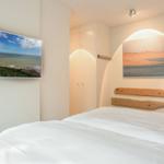 Bedroom with bed, wall art, and wardrobe.