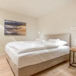 Bedroom with double bed, wall art, and window.