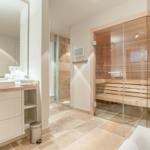 Bathroom with sauna, sink and shower.