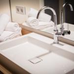 Sink with mirror and towels on wooden surface