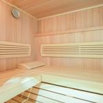 Sauna with wooden benches and wall thermometer