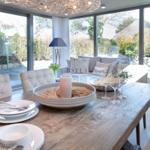 Dining area with wooden table, chairs, and garden view
